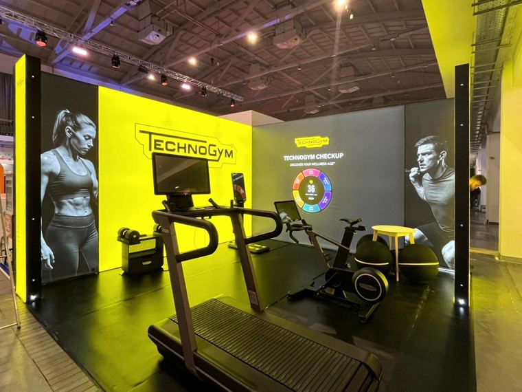 Stoisko Technogym z ekspozycją sprzętu i podświetlanymi ścianami