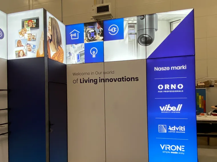 Podświetlony panel z markami i ściana z hasłem Living innovations obok kantorka
