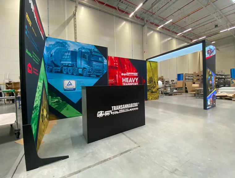 Lada z logo Transannaberg przed ścianą z grafiką ciężarówki i napisem Heavy transport