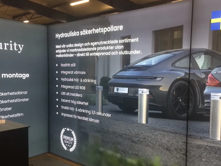 Dłuższa ściana z grafiką słupków hydraulicznych przed samochodem i listą cech produktu